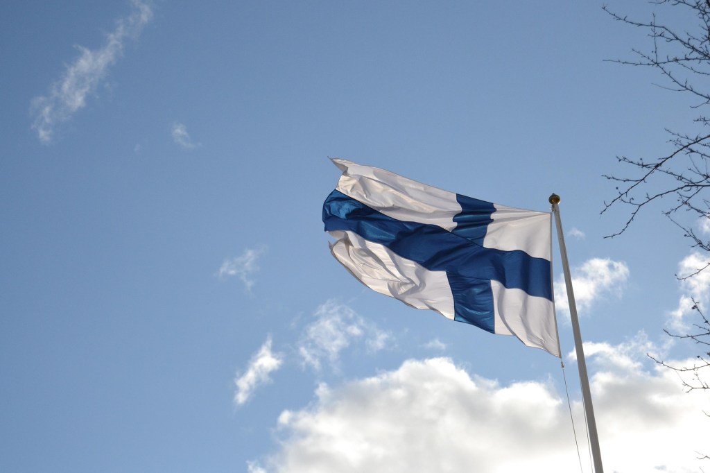 Finnish flag waving against a blue sky